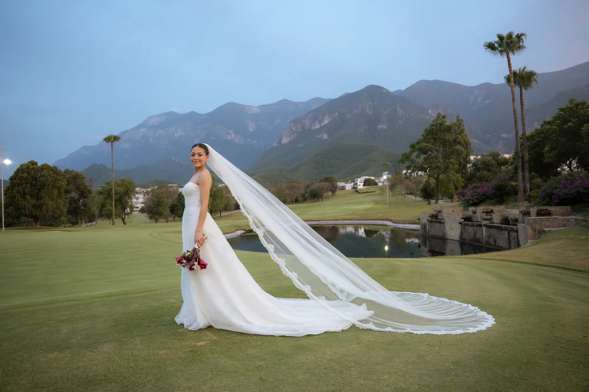 Denisse with her veil flowing in the wind, mountains behind her
